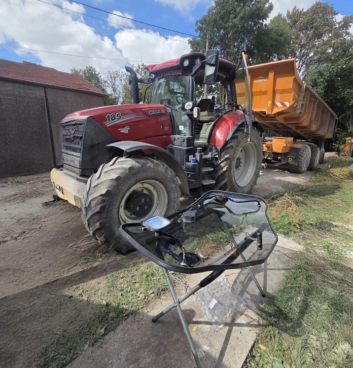Concessionnaire de machines agricoles. Un homme avec une tablette numérique en main regardant un tracteur agricole.